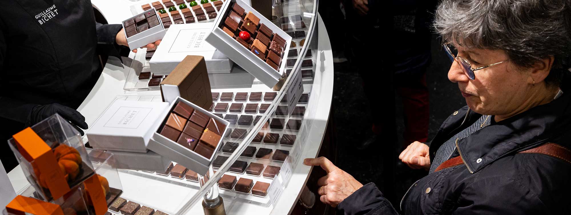 Un visiteur en train de faire son choix sur un stand de chocolat.
