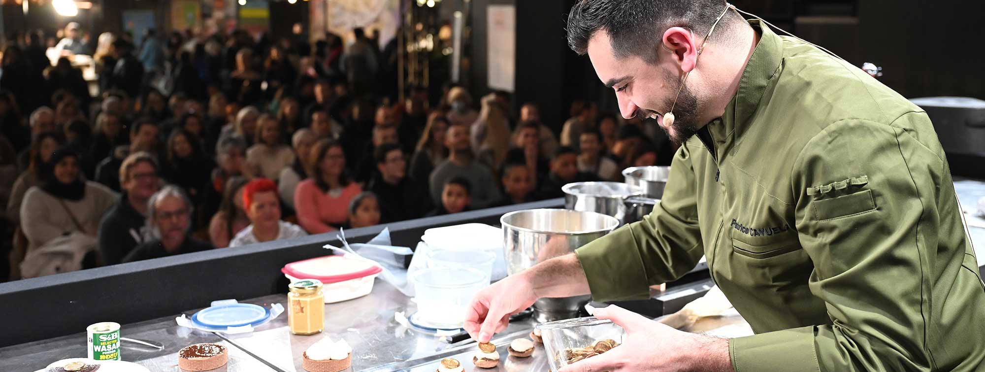 Chef en pleine démonstration d'une recette sur la scène du Pastry Show. 