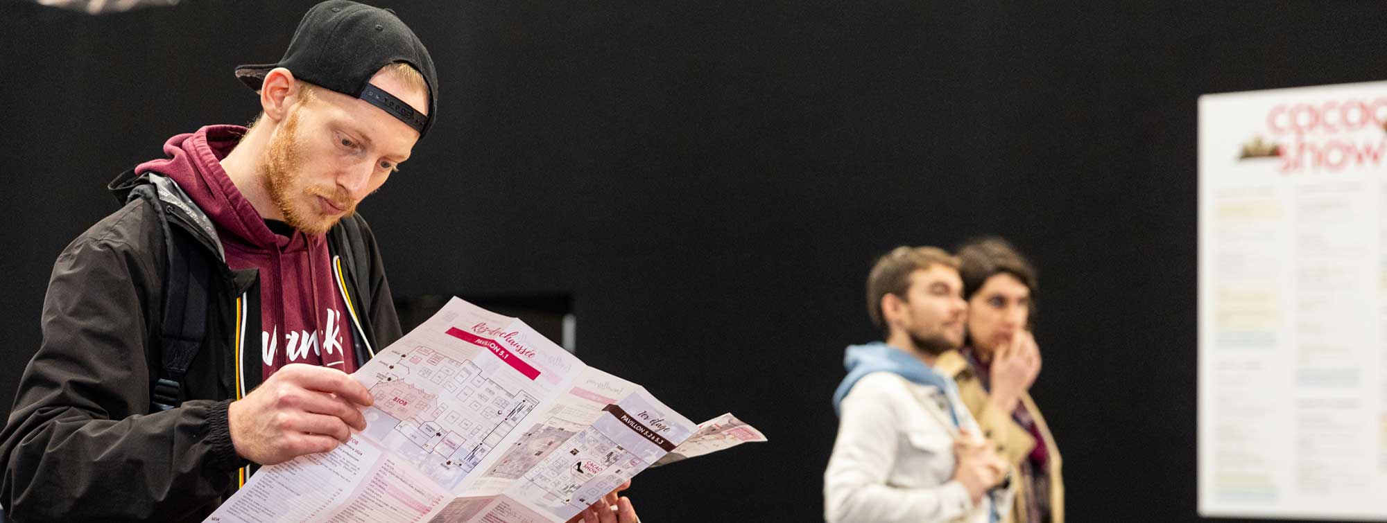 Visiteur du Salon en train de regarder le plan dépliable. 