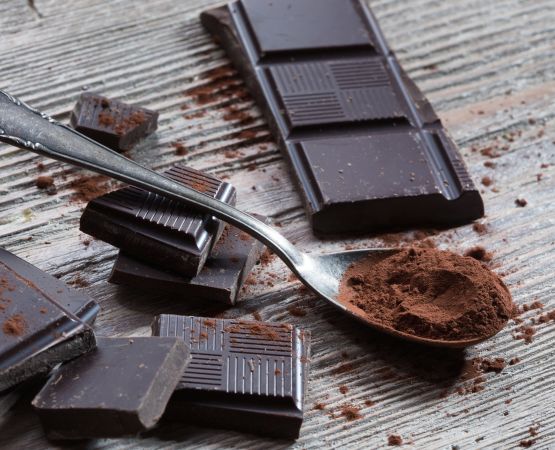 Carrés de chocolat éparpillés avec une cuillère.