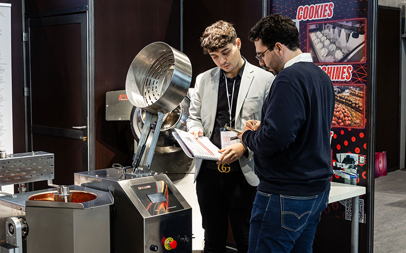 A professional presenting a machine at the Salon du Chocolat.