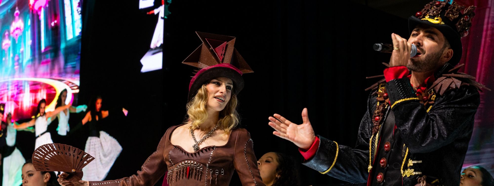 Spectacle sur scène avec chanteurs et danseurs en costumes créatifs en chocolat