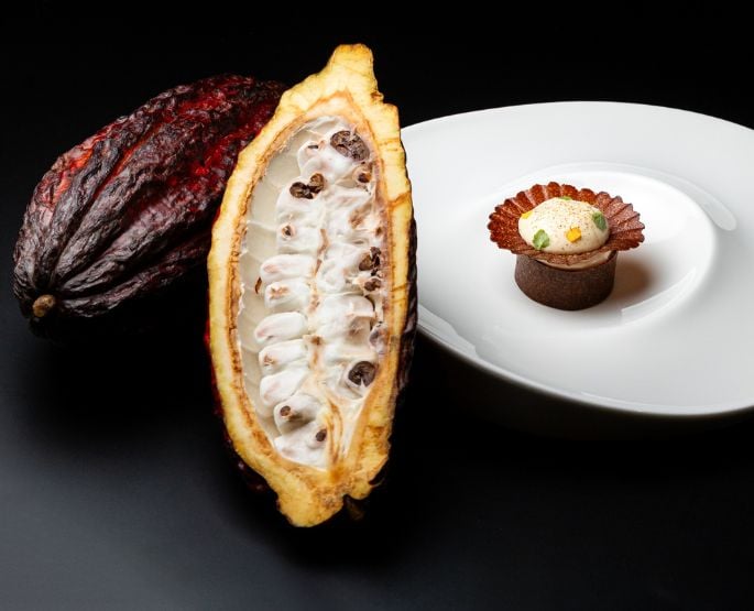 Pâtisserie au chocolat dans une assiette blanche avec une cabonne posée sur le coté.