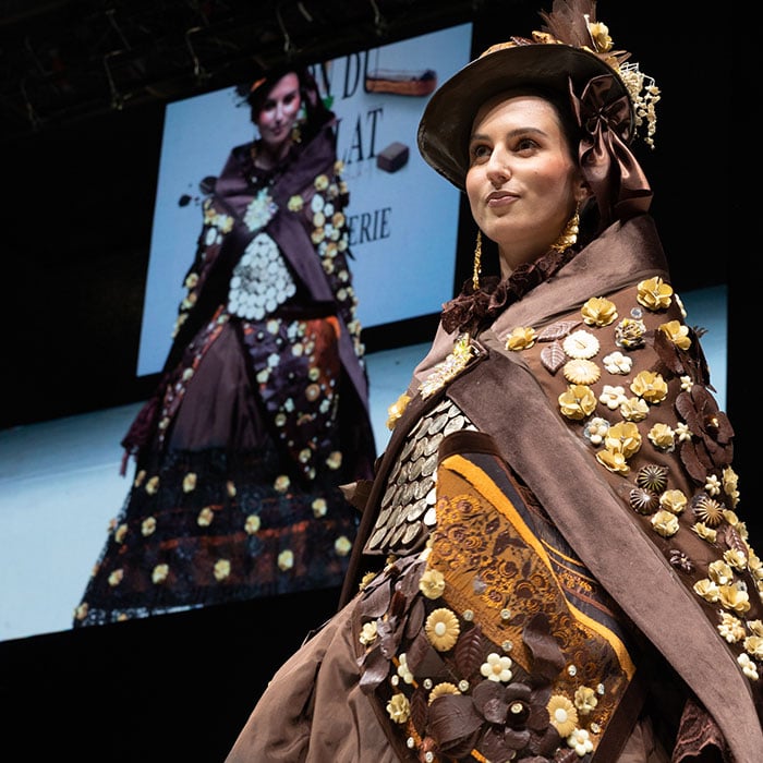 Mannequin portant une robe en chocolat durant le défilé.