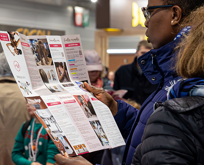 Quelqu'un qui regarde le plan dépliable du Salon du Chocolat. 