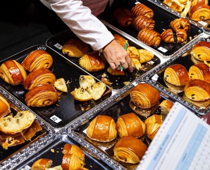 Concours de pâtisserie avec des pains au chocolat présentés sur des plateaux lors d’un événement professionnel