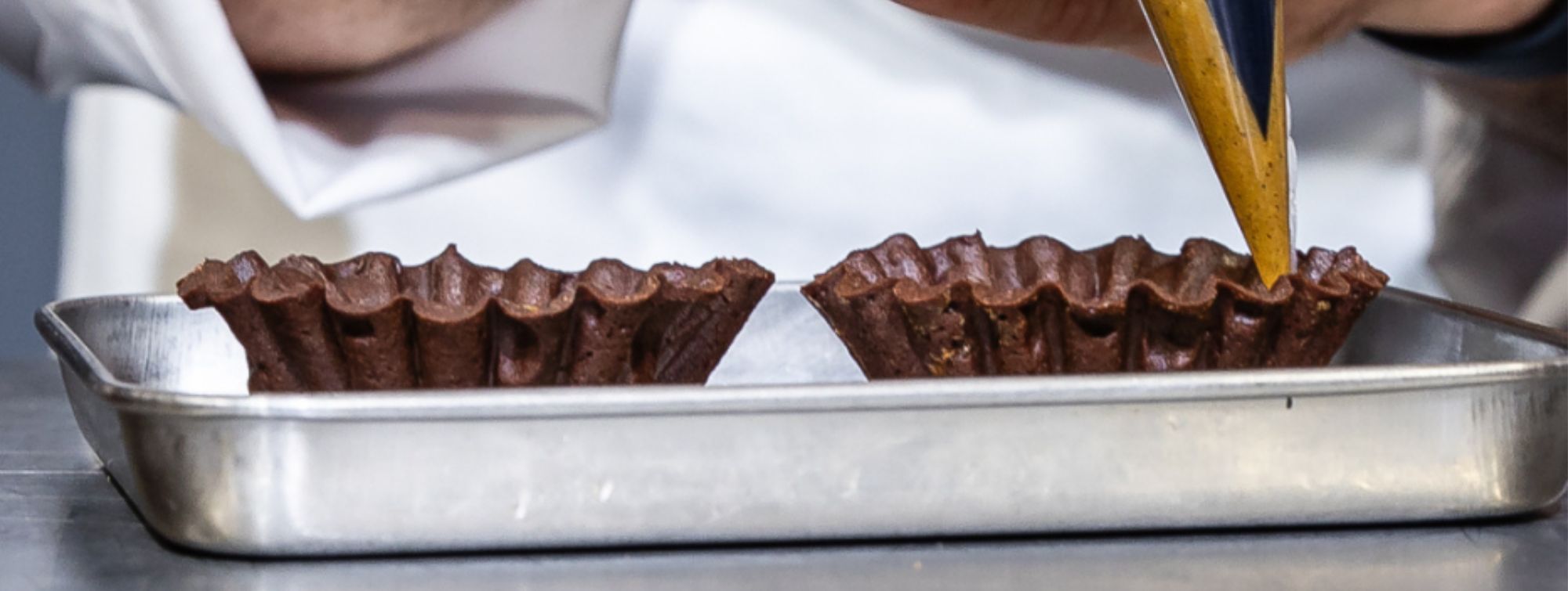 Réalisation d'un pochage d'une pâtisserie en cours.