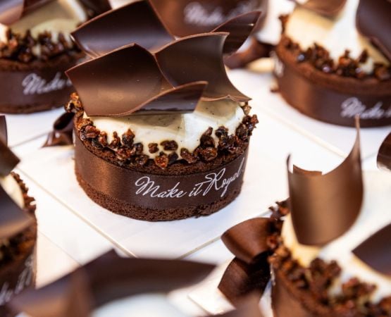 Gâteau au chocolat décoré de chocolat et d’un ruban.