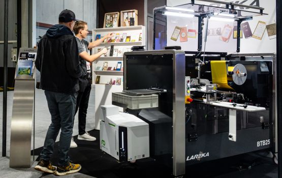 An exhibitor talking to a visitor at their booth in the BtoB Village.