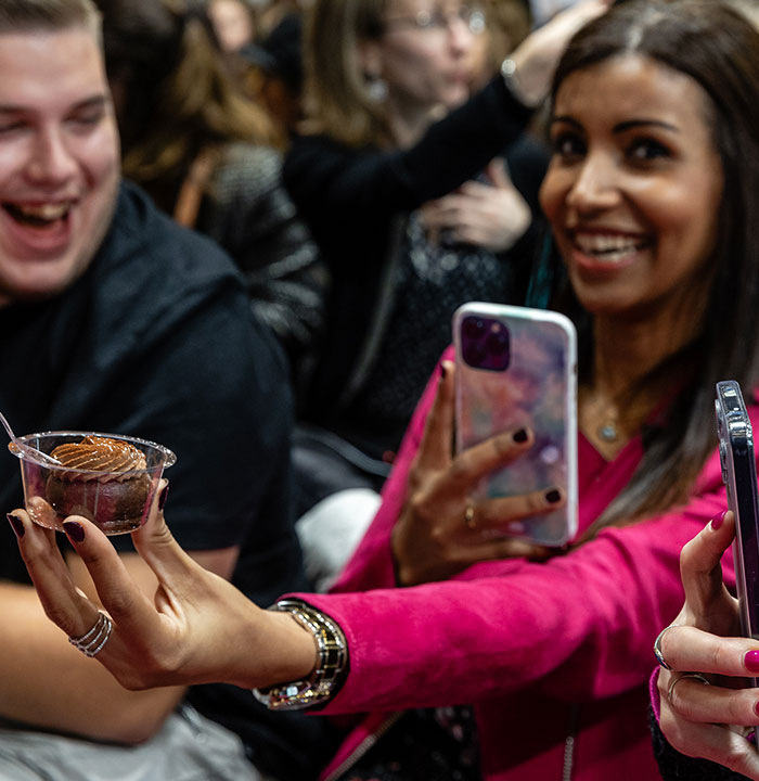 Visiteur en train de prendre en photo la pâtisserie reçue lors de la démonstration sur le Pastry Show. 